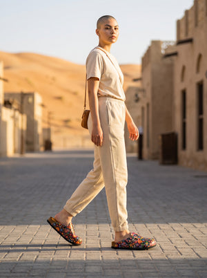 Calceo.co black clogs with a vibrant multi-colored floral pattern, adjustable buckle, and cork sole.
